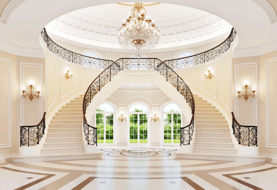 Grand staircase with chandelier and arched windows.